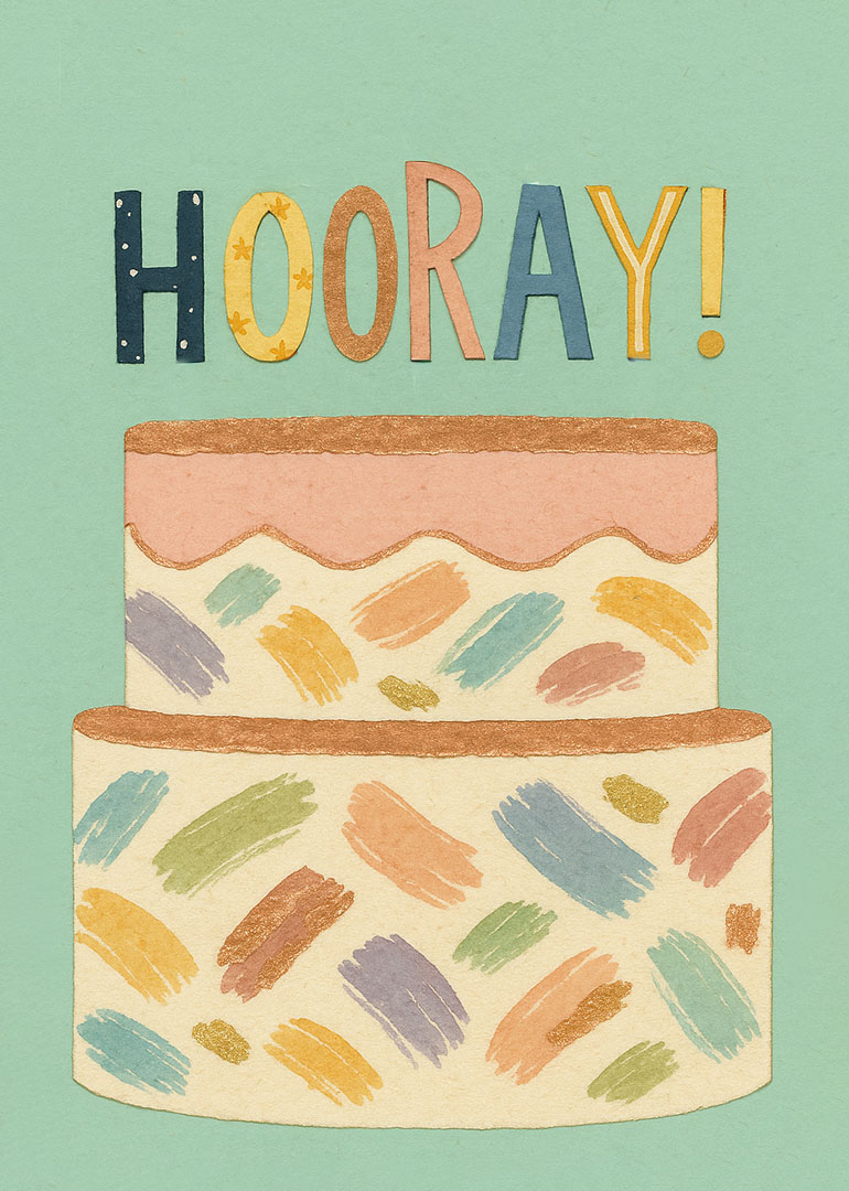 Colorful painted birthday cake with hooray text on green background