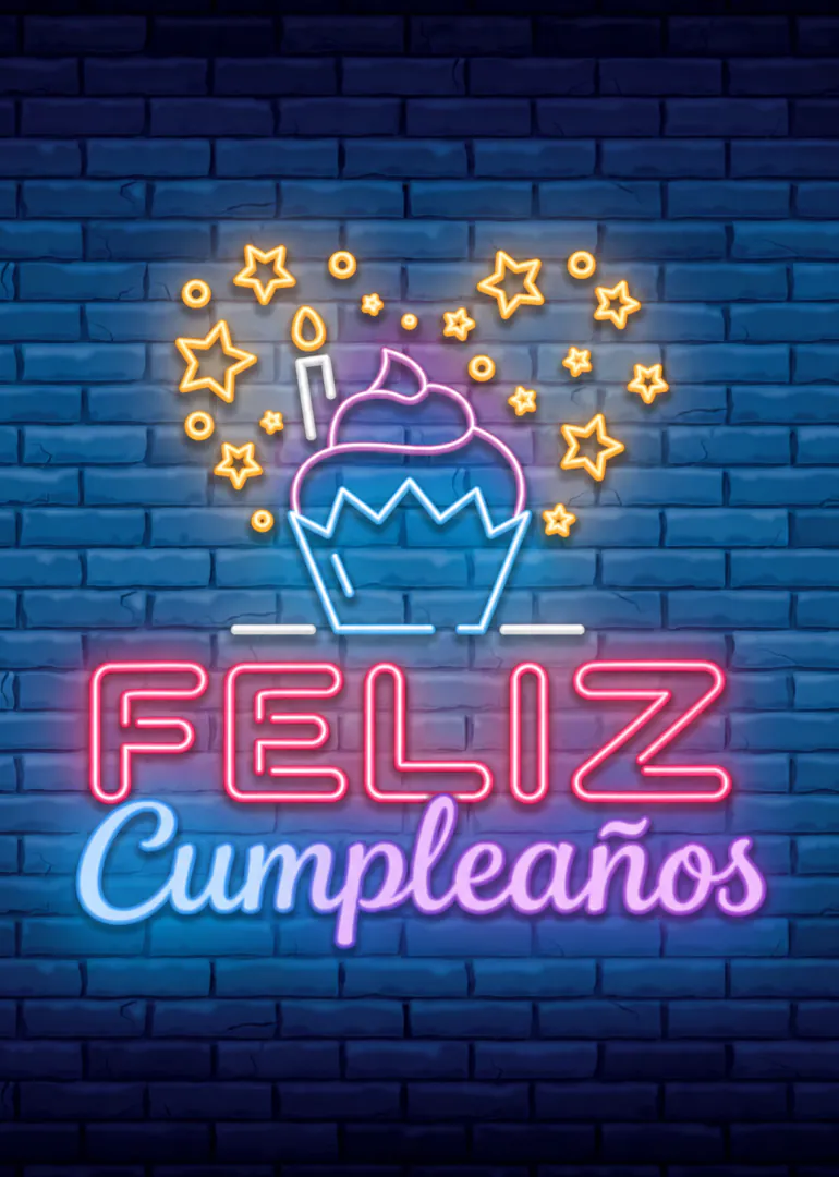 Tarjeta vertical con un cupcake, estrellas y el mensaje luminoso «FELIZ Cumpleaños» sobre una pared de ladrillos azul.