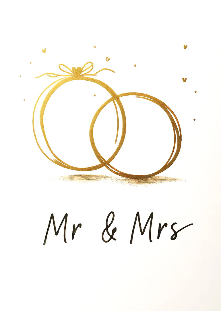 Two gold wedding rings with hearts above and Mr and Mrs text on white background.
