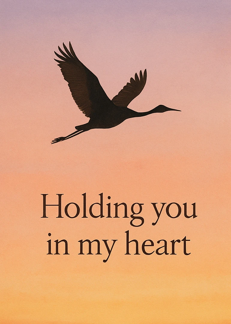 Silhouette of a flying bird against a sunset sky with Holding you in my heart.