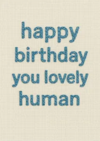 Blue embroidered happy birthday text on cream fabric for a lovely human with soft texture.