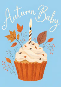 Blue card featuring an iced cupcake with a lit striped candle, autumn leaves and the words “Autumn Baby”.