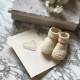Photograph of a heartfelt paternity leave card placed next to new born baby booties