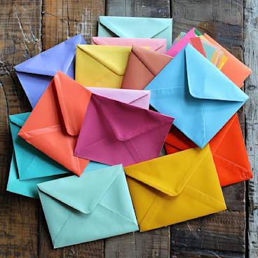 Vibrant collection of leaving card envelopes on a wooden table